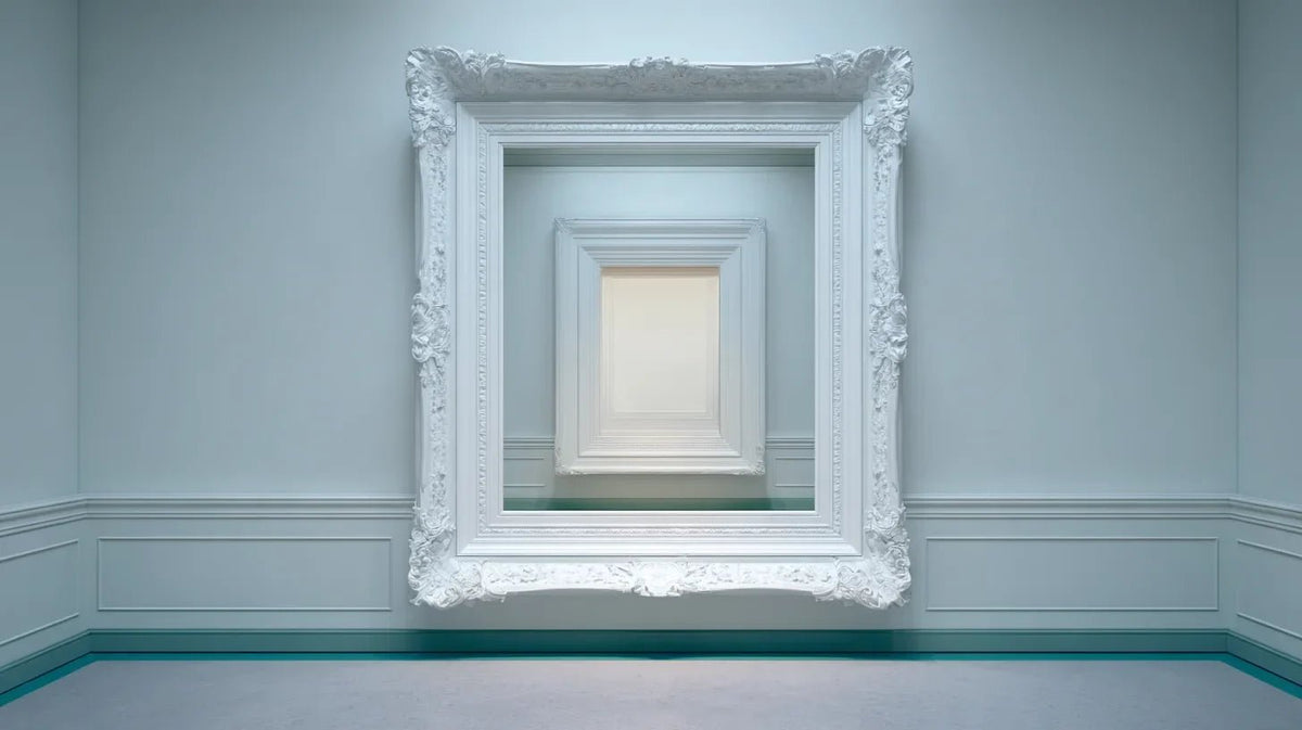 An ornate white picture frame on a pale gallery wall with a much smaller frame nested inside it, a thin teal line along the floor